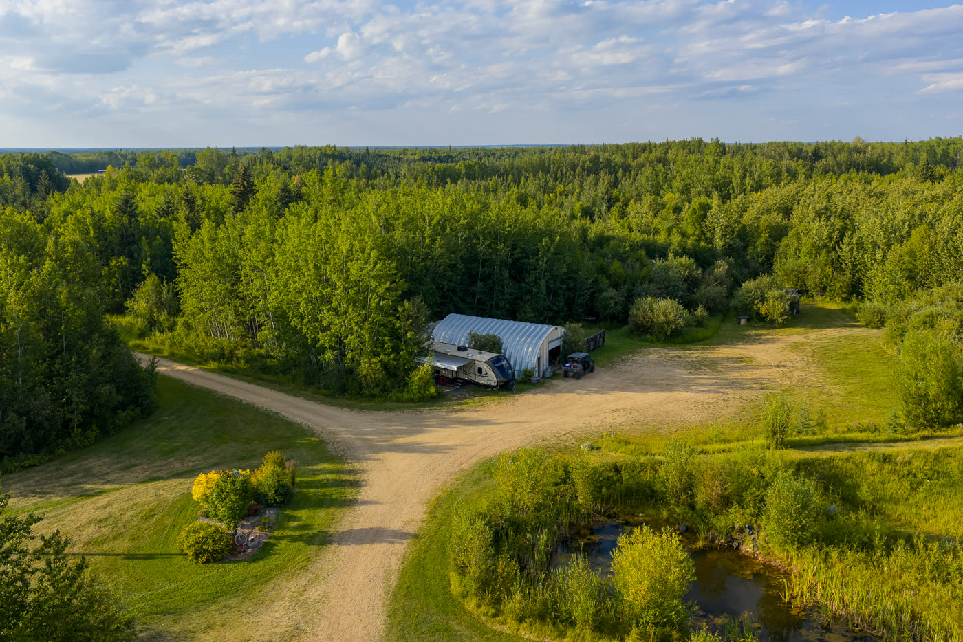 The RV parking area from above, the pond and trail beyond it