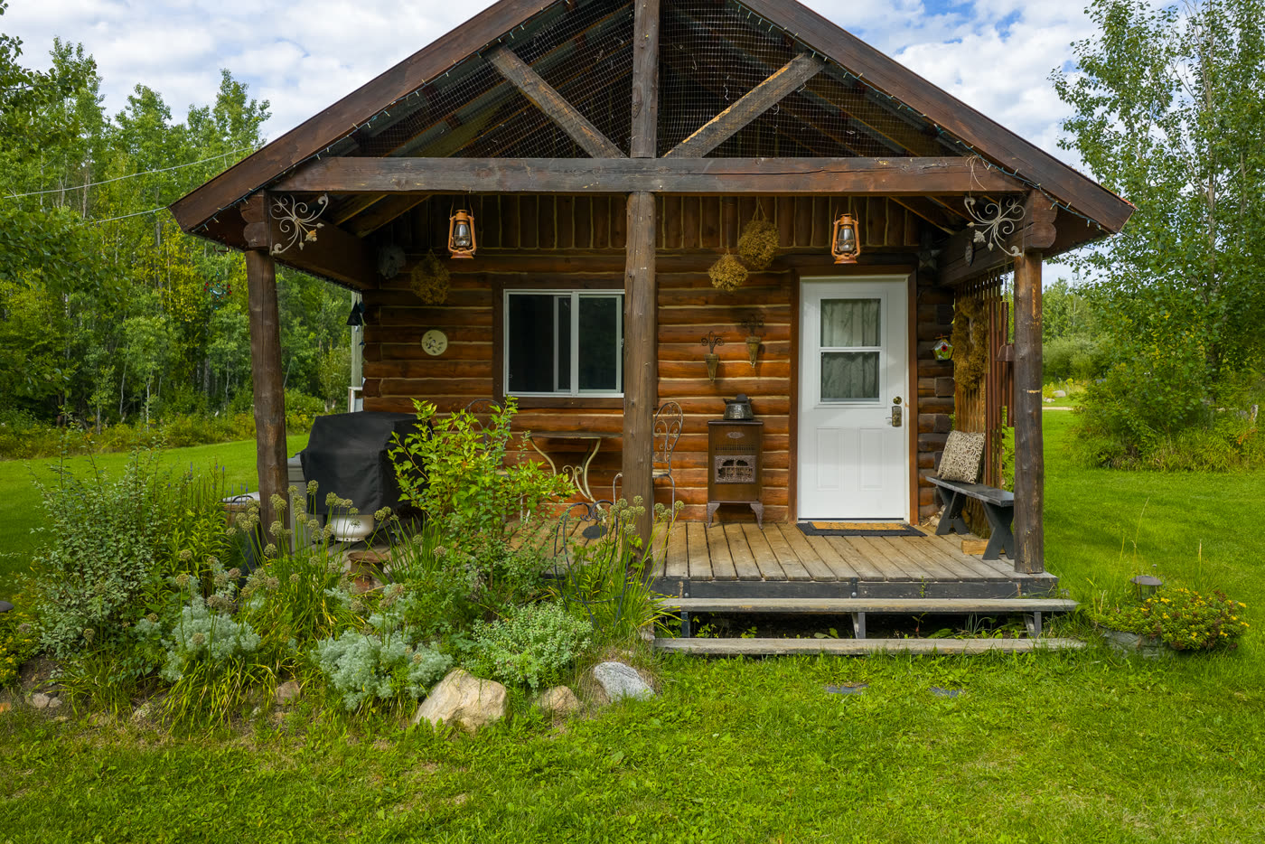 The guest cabin, its covered porch hung with lanterns