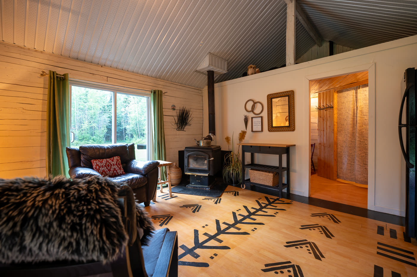 Inside the guest cabin: a wood stove, patterned rug and seating
