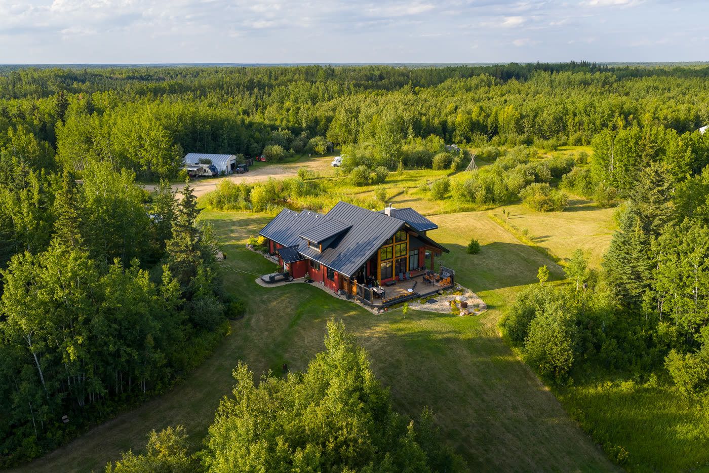 The lodge in evening light, lawns running down to the treeline