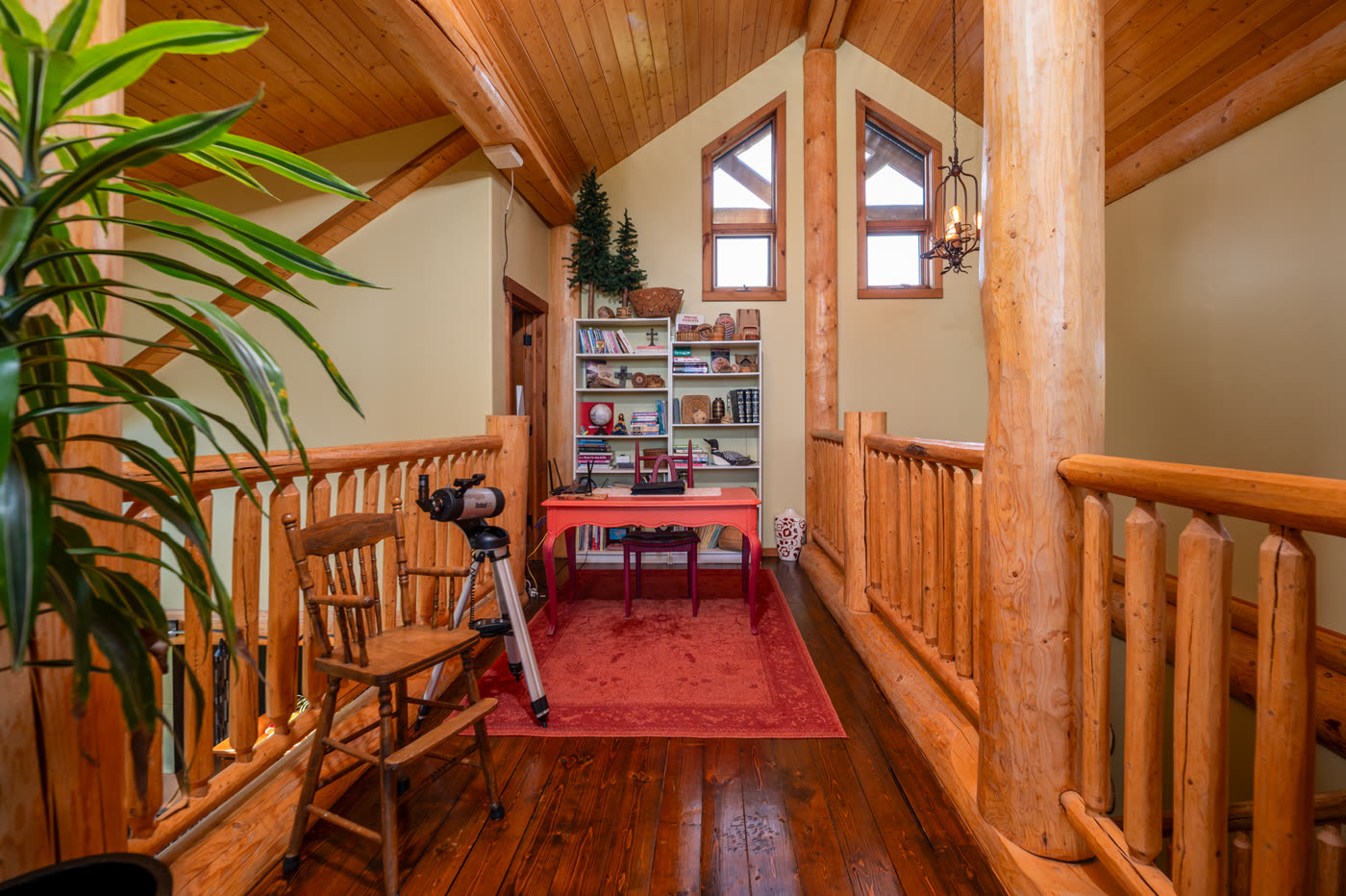 The upper landing, its log railing looking down into the great room