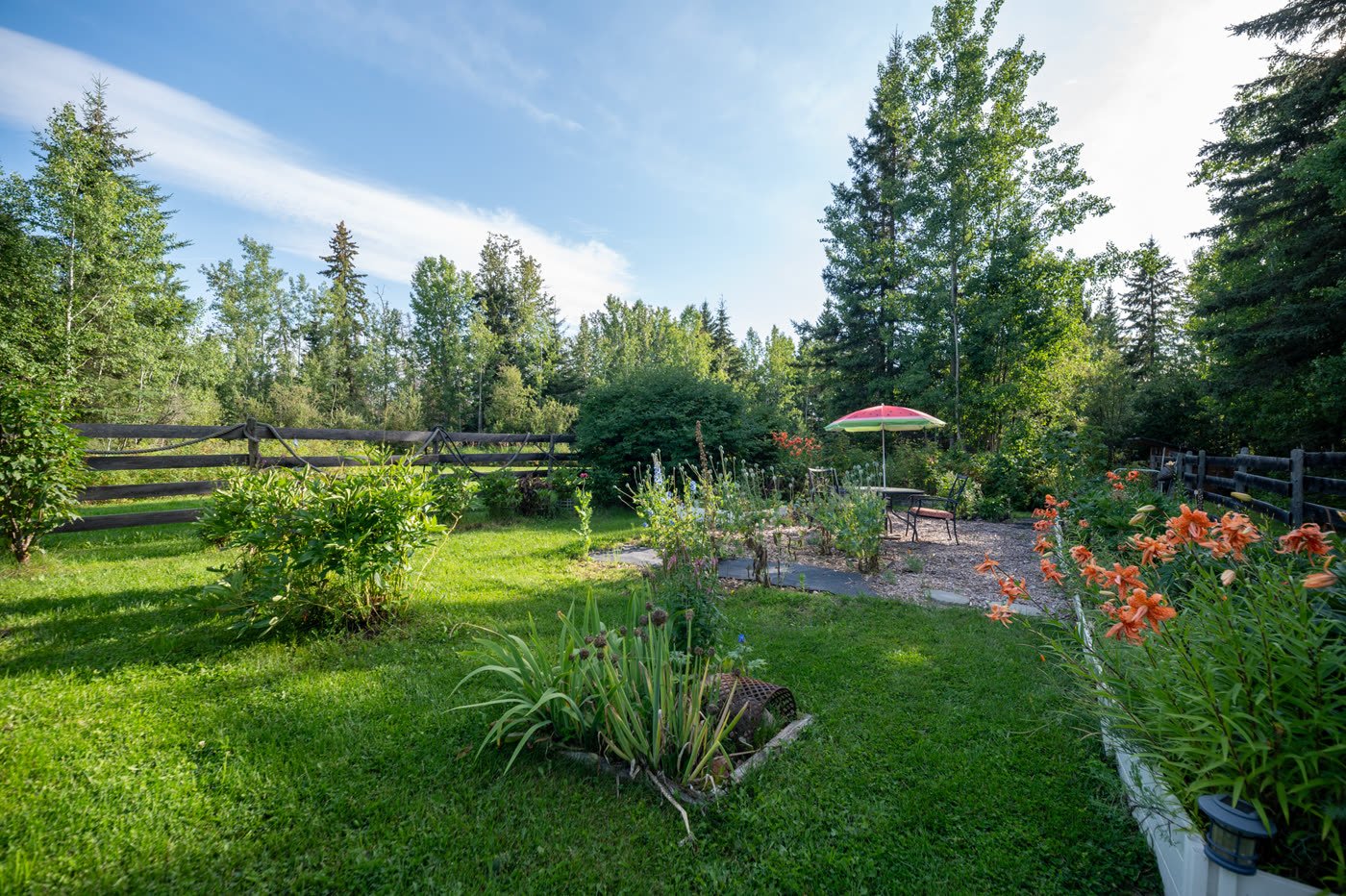 Garden beds and lawn, a gazebo at the far edge